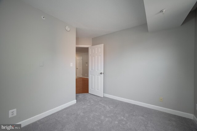 carpeted spare room featuring baseboards