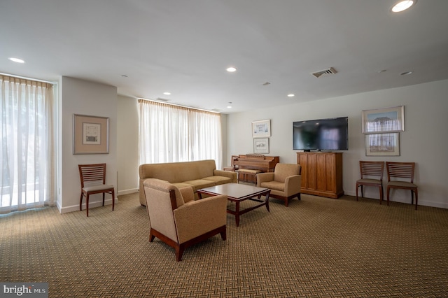 living area featuring baseboards, carpet floors, visible vents, and a wealth of natural light