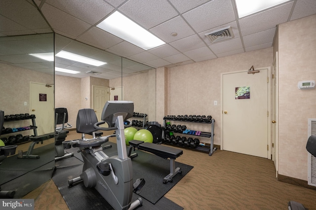 workout area with a drop ceiling and dark colored carpet