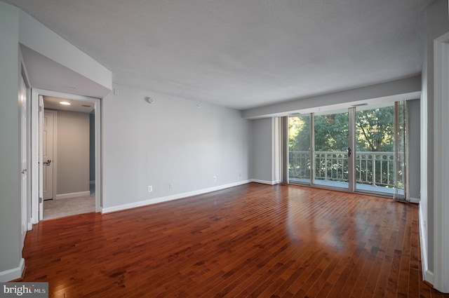 empty room featuring a textured ceiling and hardwood / wood-style floors