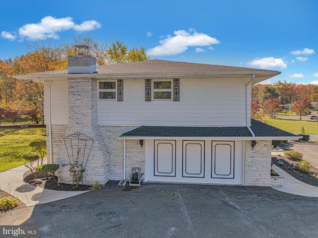 view of property with a garage and a front lawn