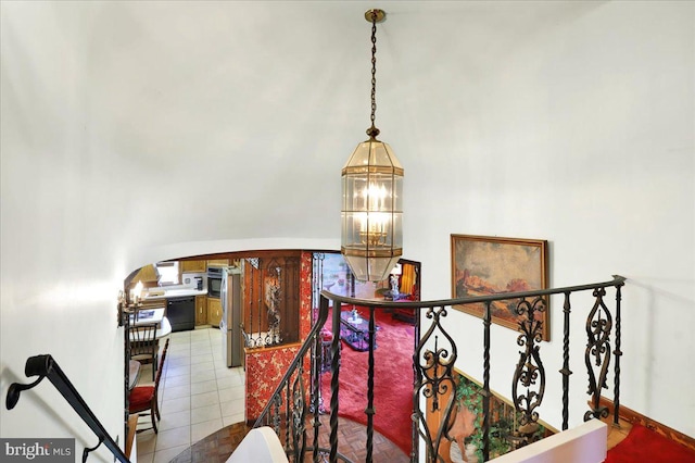 stairs featuring tile patterned floors and a notable chandelier