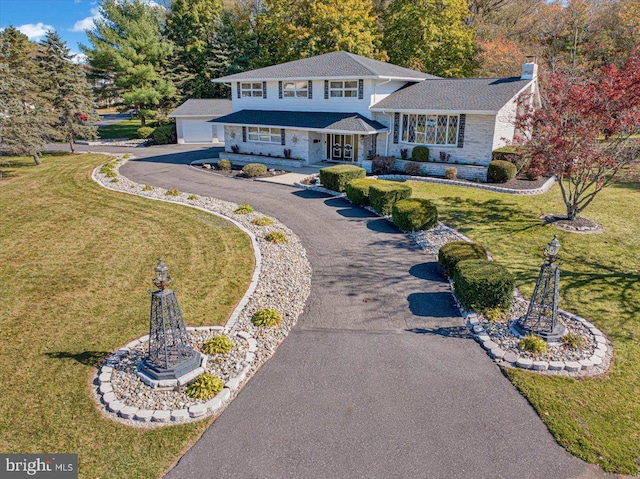 333 W Arch St, Frackville, PA 17931 - split level home featuring a chimney, an outdoor structure, stone siding, a detached garage, and a front lawn