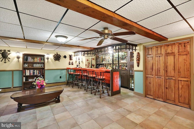 bar with ceiling fan, beamed ceiling, and baseboard heating