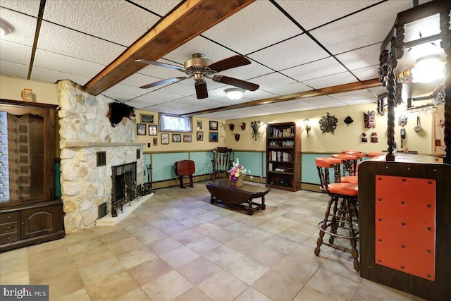 333 W Arch St, Frackville, PA 17931 - living area featuring a baseboard radiator, a drop ceiling, ceiling fan, a stone fireplace, and baseboards