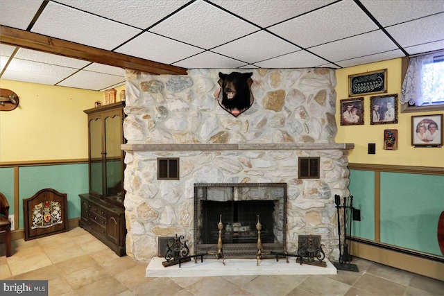 room details with baseboard heating, a drop ceiling, and a fireplace