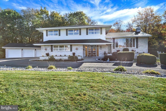 view of front of property with a garage and a front lawn