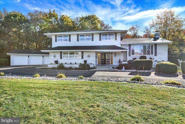 333 W Arch St, Frackville, PA 17931 - view of front facade with a front lawn, a detached garage, stone siding, a chimney, and french doors