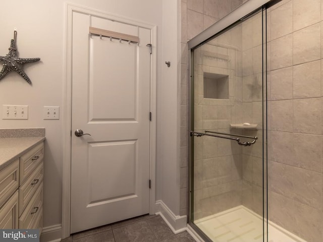 bathroom featuring vanity, walk in shower, and tile patterned flooring