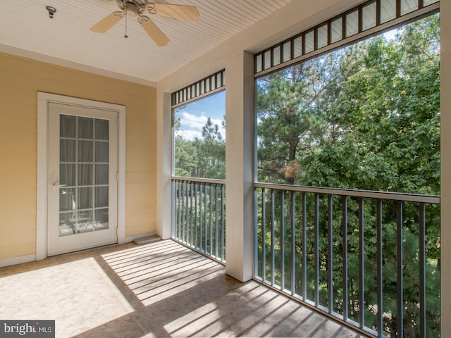 unfurnished sunroom with ceiling fan