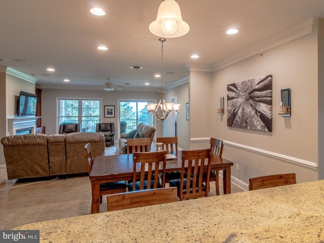 dining space featuring crown molding and ceiling fan with notable chandelier