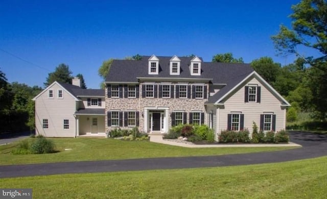 colonial inspired home with a front yard