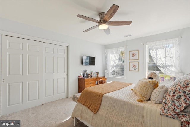 carpeted bedroom featuring a closet and ceiling fan