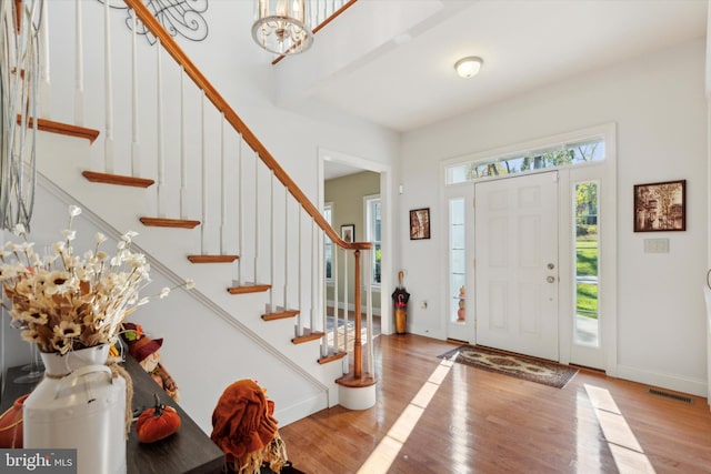 entryway with beam ceiling and light hardwood / wood-style flooring