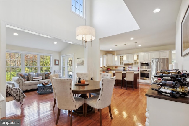 dining area with lofted ceiling and light wood-type flooring