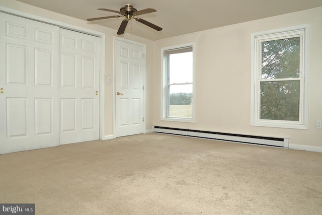 unfurnished bedroom with ceiling fan, light carpet, multiple windows, and baseboard heating