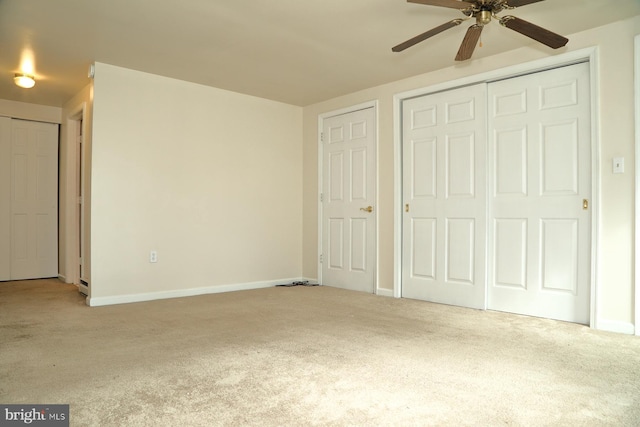 unfurnished bedroom with multiple closets, carpet floors, and ceiling fan