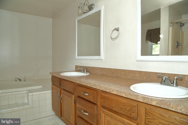 bathroom with vanity, tile patterned flooring, and tiled tub