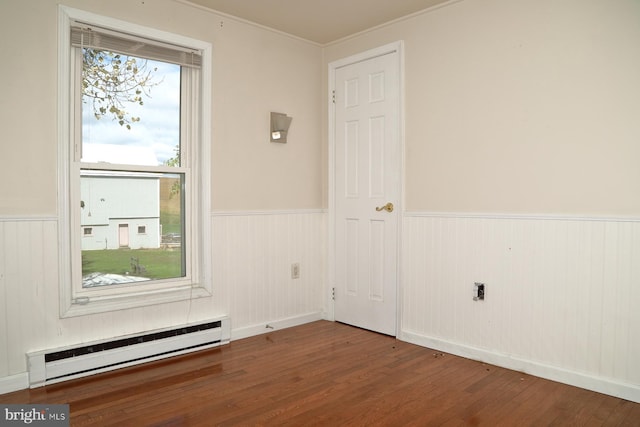 spare room featuring hardwood / wood-style flooring and a baseboard radiator