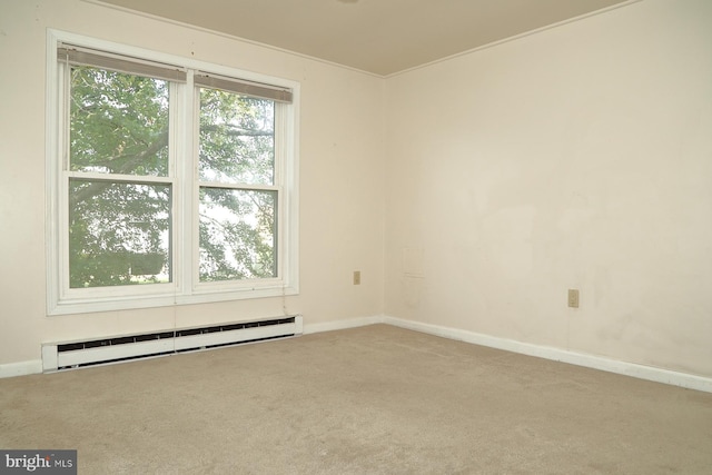 spare room featuring a baseboard heating unit and carpet flooring