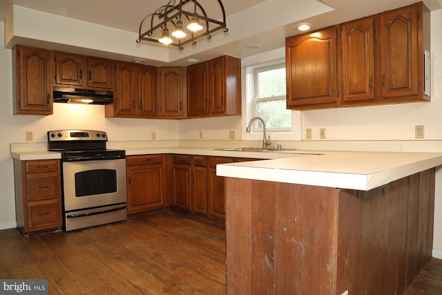 kitchen featuring kitchen peninsula, hanging light fixtures, electric range, and dark hardwood / wood-style flooring