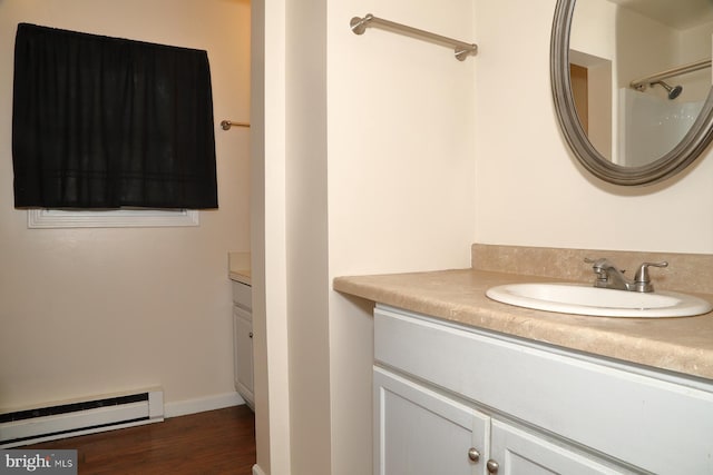 bathroom featuring vanity, a baseboard heating unit, and hardwood / wood-style floors