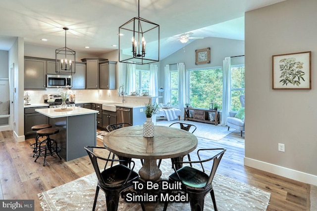 dining space with sink, vaulted ceiling, light hardwood / wood-style flooring, and ceiling fan