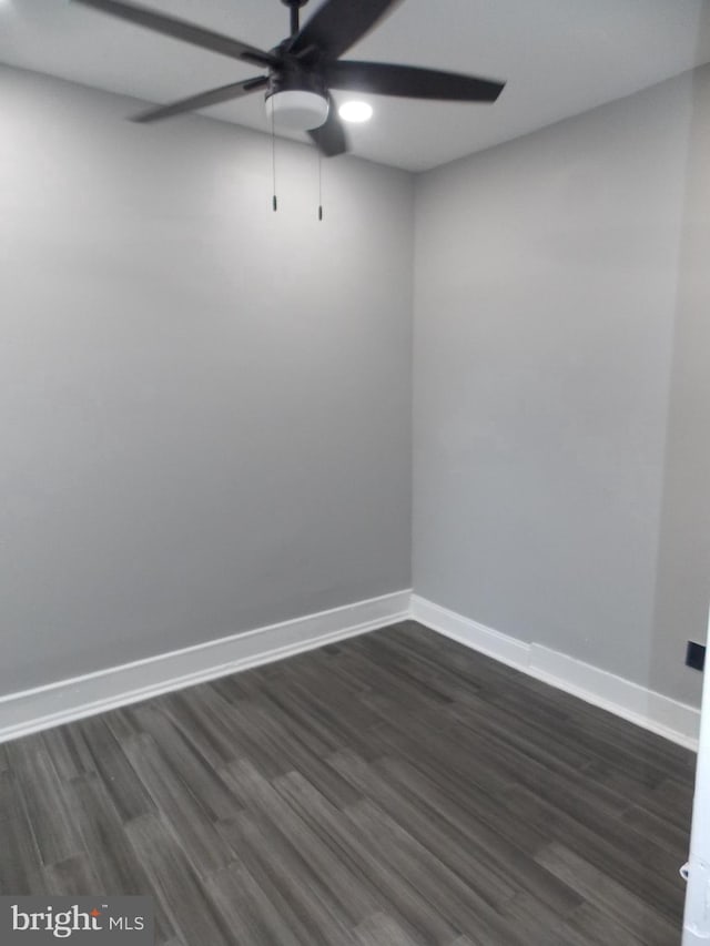 unfurnished room featuring dark wood-type flooring and ceiling fan