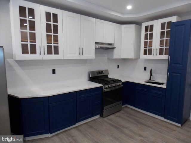 kitchen with light hardwood / wood-style floors, gas range, sink, and blue cabinets