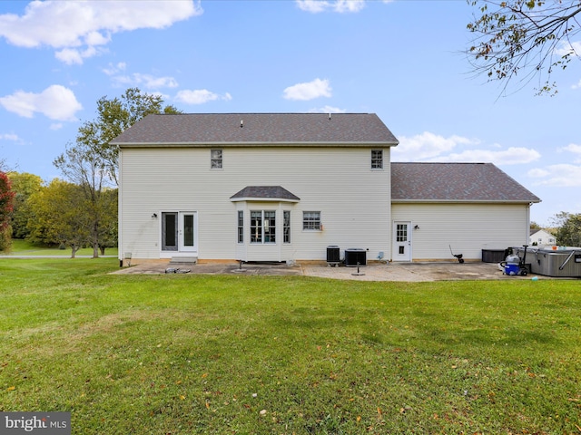 back of property featuring a lawn, central air condition unit, and a patio area