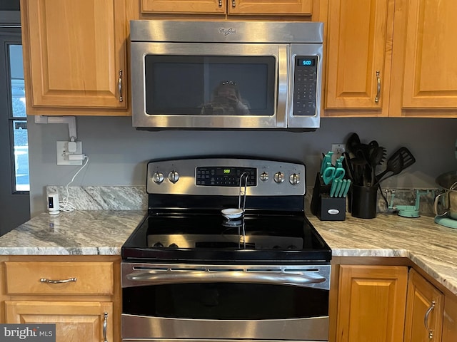 kitchen with light stone counters and stainless steel appliances