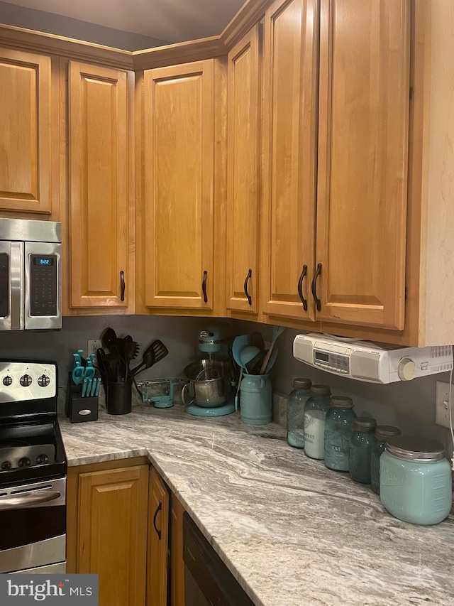 kitchen with appliances with stainless steel finishes and light stone counters