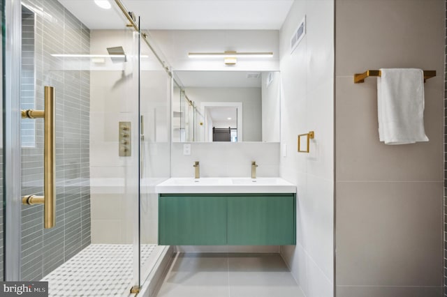 bathroom with vanity, tile walls, tile patterned flooring, and a shower with door