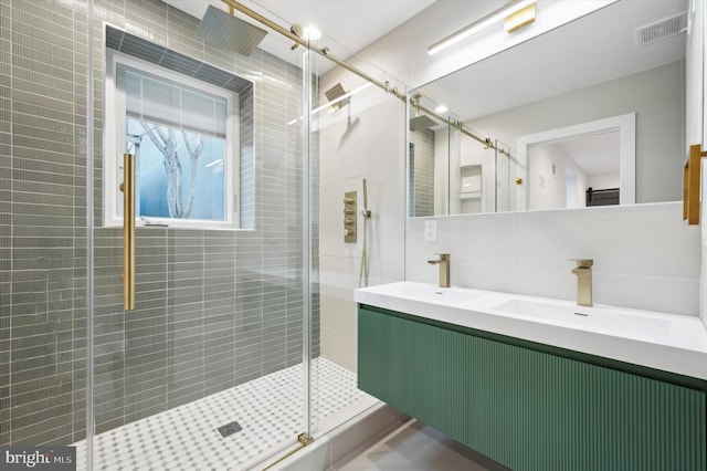 bathroom featuring vanity, backsplash, and a shower with shower door