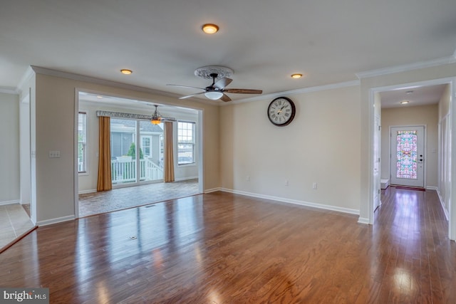 spare room with a wealth of natural light, hardwood / wood-style floors, crown molding, and ceiling fan