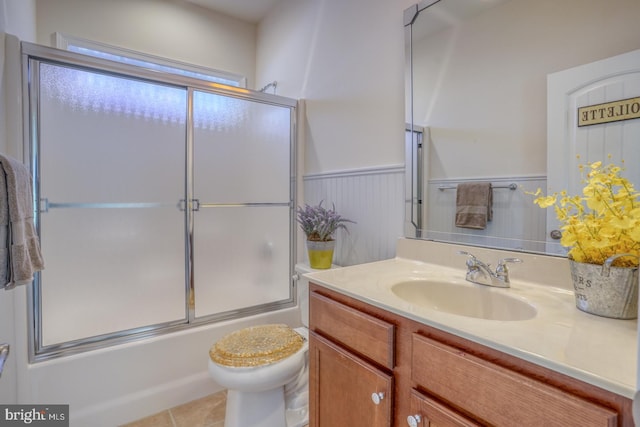 full bathroom with vanity, toilet, tile patterned floors, and bath / shower combo with glass door