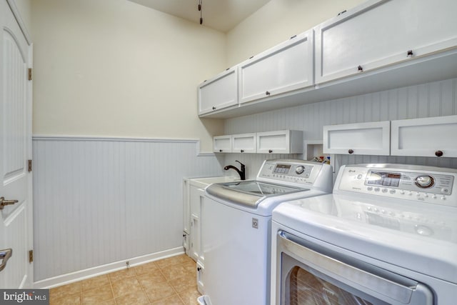 washroom with sink, washing machine and clothes dryer, and cabinets