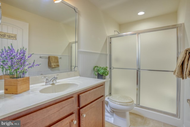 bathroom featuring vanity, tile patterned flooring, toilet, and a shower with door