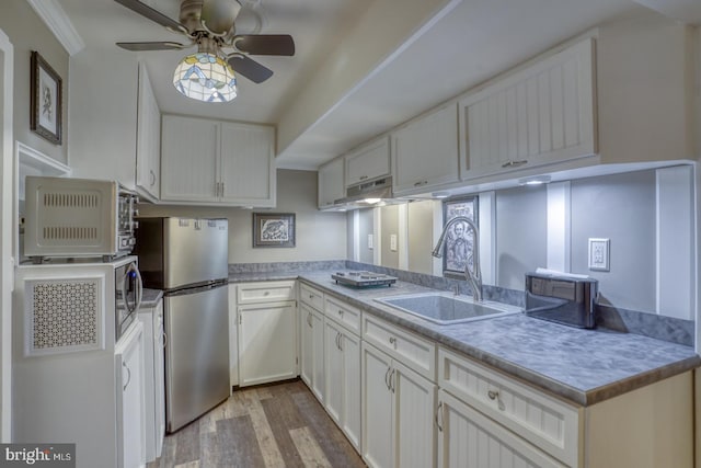 kitchen with sink, light wood-type flooring, white cabinetry, stainless steel refrigerator, and ceiling fan