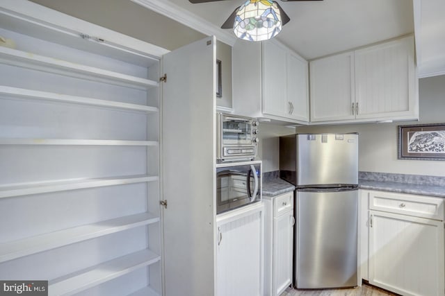 kitchen featuring white cabinetry, light hardwood / wood-style flooring, stainless steel appliances, and ceiling fan