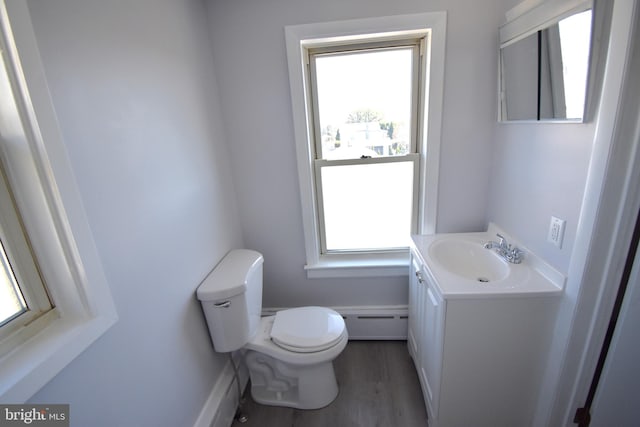 bathroom with a healthy amount of sunlight, vanity, a baseboard heating unit, and toilet