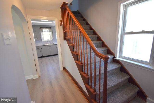 staircase featuring hardwood / wood-style floors and sink