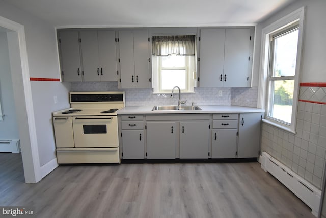 kitchen with light hardwood / wood-style floors, white electric stove, sink, and a baseboard radiator