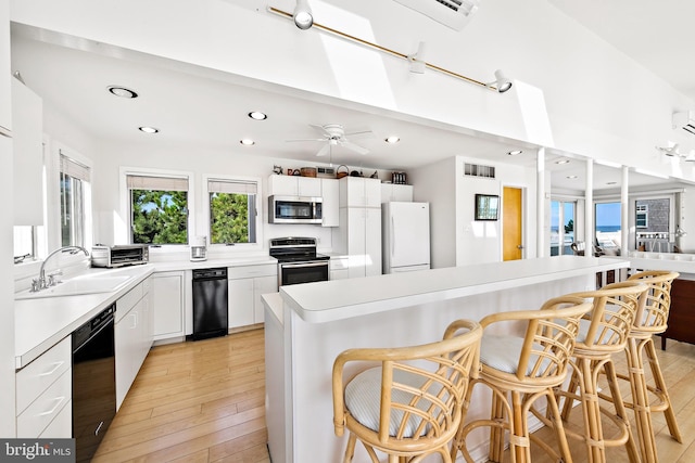 1039 Long Beach Blvd, Long Beach Township, NJ 08008 - kitchen with appliances with stainless steel finishes, a sink, a breakfast bar, white cabinets, and ceiling fan