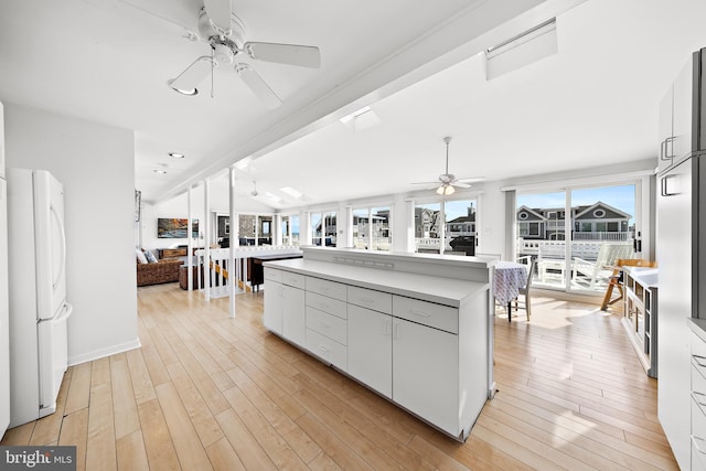 1039 Long Beach Blvd, Long Beach Township, NJ 08008 - kitchen with a ceiling fan, freestanding refrigerator, light countertops, a kitchen island, and light wood-style floors