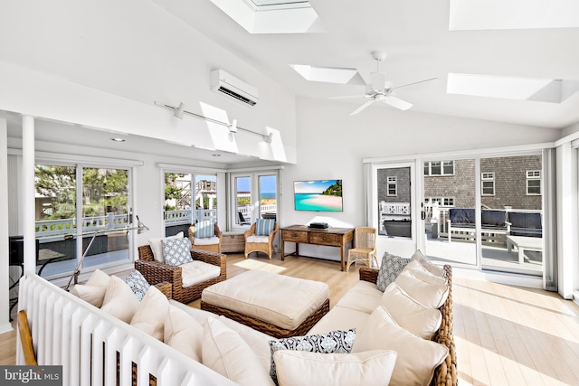 living room with light wood-style floors, a wall mounted air conditioner, ceiling fan, and lofted ceiling with skylight