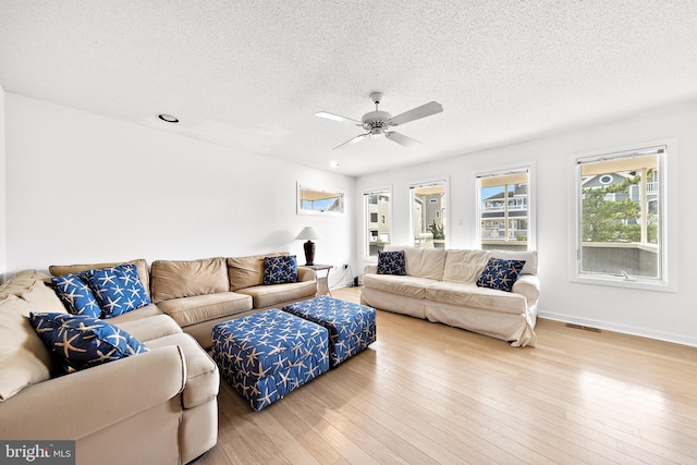 1039 Long Beach Blvd, Long Beach Township, NJ 08008 - living area featuring a textured ceiling, wood finished floors, a ceiling fan, and baseboards