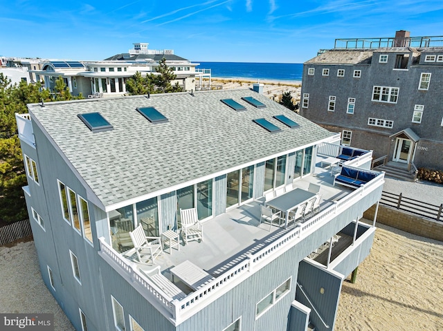 1039 Long Beach Blvd, Long Beach Township, NJ 08008 - rear view of house featuring a water view, a shingled roof, and solar panels