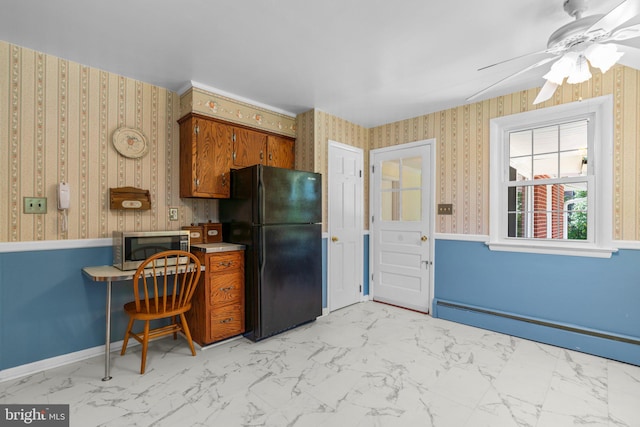 kitchen featuring ceiling fan, a baseboard radiator, and black fridge