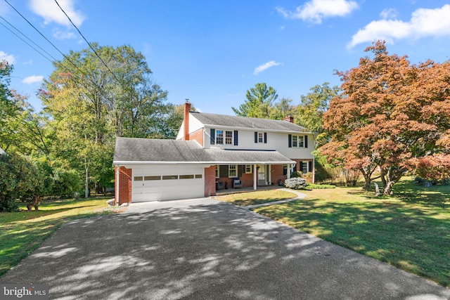 view of front facade with a front yard, covered porch, and a garage